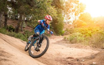 Speedy 7 Year Old Riding A Mountain Bike speeding through a forest.  Motion blur captures the essence of speed.